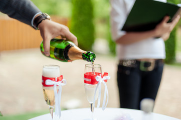 The waiter pours champagne in crystal glasses