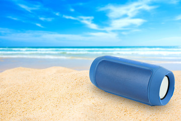 Portable wireless speakers on the beach and blue sky.