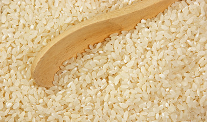 raw rice and wooden spoon