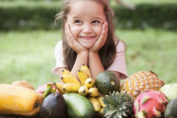 Exotic fruit on wooden table. Summer background with Laughing happy girl