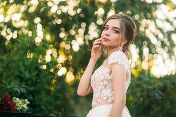 Young girl in wedding dress in park posing for photographer. portrait