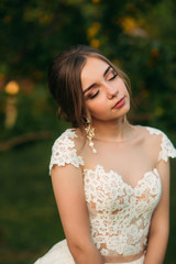 Naklejka premium Young girl in wedding dress in park posing for photographer. portrait