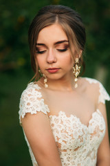 Young girl in wedding dress in park posing for photographer. portrait