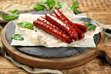 Composition with yummy grilled sausages on wooden table