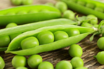 Fresh green peas on wooden background, closeup