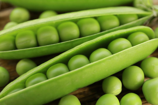 Fresh green peas on wooden background, closeup
