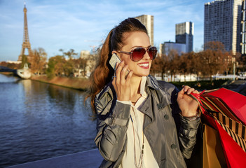 elegant woman with shopping bags speaking on mobile in Paris