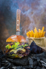 Tasty smoked grilled and glazed beef burger with lettuce, cheese and bacon served with french fries...