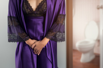 The woman in  purple satin sleepwear and robe wake up for go to restroom. People with urinary...