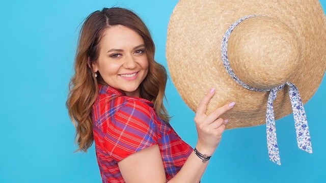 Young woman with hat over blue background