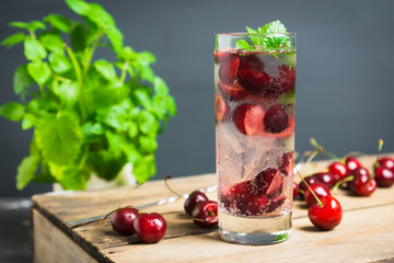 Cherries mojito on the wooden background. Selective focus.