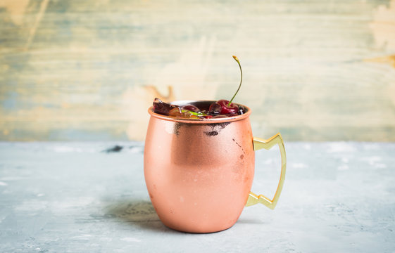Cherry moscow mule on the wooden background. Selective focus.