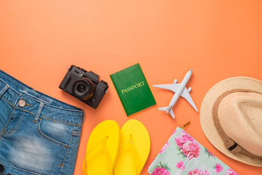 Summer traveling concept. Vacation accessories on orange background.