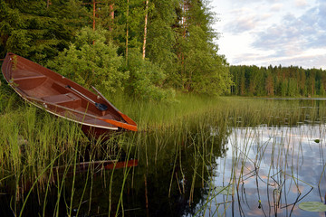 A rowing boat on the lake shore. © JRJfin