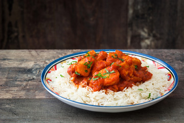 Chicken tikka masala with basmati rice on wooden table
