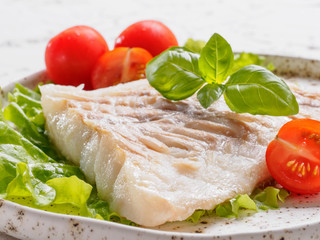 Close up grilled codfish with basil and cherry tomatoes