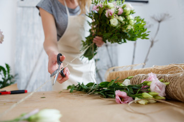Obraz na płótnie Canvas Girl florist makes beautiful bouquet
