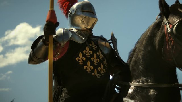 Medieval knight with lance riding horse to joust tournament
