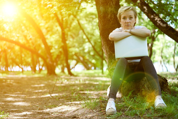 girl geek in the forest with the computer