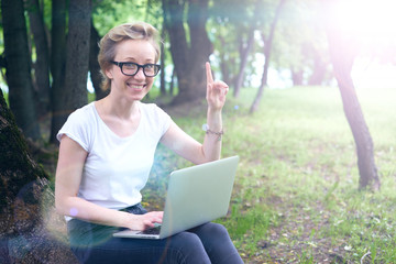 girl geek in the forest with the computer