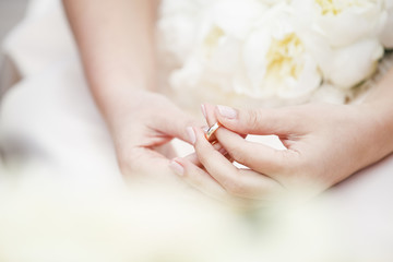 Obraz na płótnie Canvas dettaglio mani che tengono teneramente un anello con dei fiori