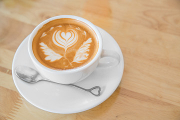 Hot milk latte art coffee on wooden table