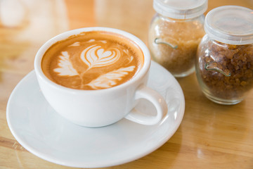 Hot milk latte art coffee on wooden table