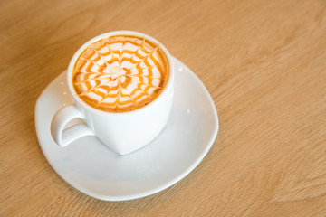 Hot caramel macchiato on wooden table.