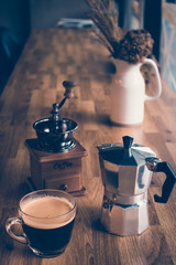 Hot black coffee with vintage coffee maker on table in coffee shop