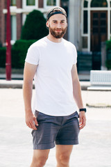 Model with beard  wearing white blank  t-shirt with space for your logo or design in casual urban style