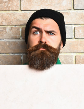 Bearded brutal caucasian hipster with white paper sheet