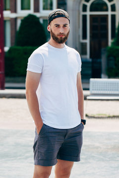 Model with beard  wearing white blank  t-shirt with space for your logo or design in casual urban style