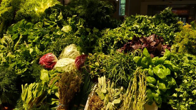 A lot of greenery and cabbege at the counter