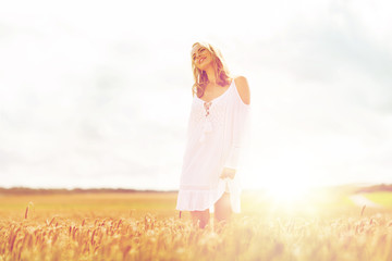 Fototapeta na wymiar smiling young woman in white dress on cereal field