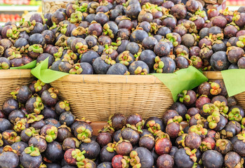 Fresh mangosteen queen of fruits (Garcinia mangostana Linn) in the basket at supermarket, healthy purple mangosteen fruit food