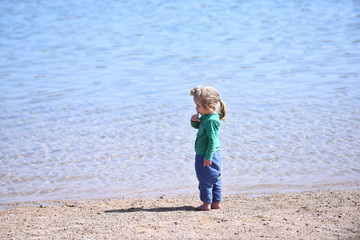 Adorable little blond kid boy at ocean beach