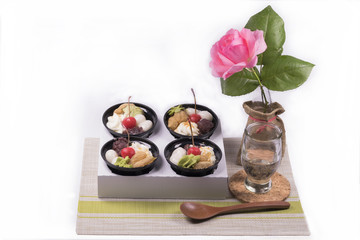 Dessert with red berries and green tea cream,wooden spoon, with beautiful pink rose on  white background