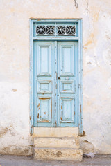 Fototapeta na wymiar old light blue door with steps in Tunisia
