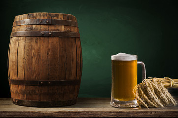 Beer barrel with beer glass on table on wooden background