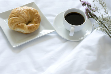 croissant and a cup of black coffee