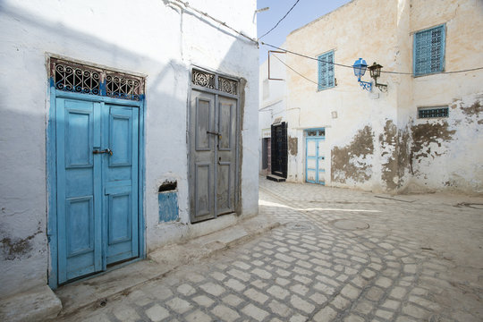 street with blue door and broken wall in Tunisia