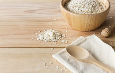 healthy food concept. oatmeal in wooden bowl on old table with soft-focus and over light in the background