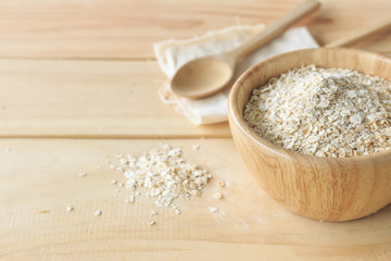 healthy food concept. oatmeal in wooden bowl on old table with soft-focus and over light in the background
