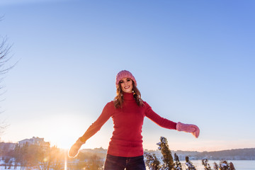 Winter portrait of a Happy candid beautiful young lady in a pink knitted beanie hat and gloves