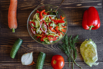 Vegetables for salad. Tomato cabbage onion cucumber carrot pepper on a wooden board