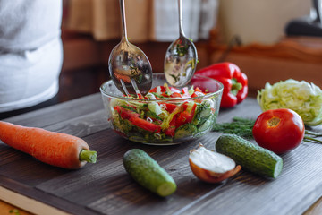 housewife mixing vegetable salad
