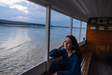 summer vacation. happy portrait beautiful woman girl caucasian asian woman mixed in blue shirt posing on background sky lake water sunset long hair brunette on the ship