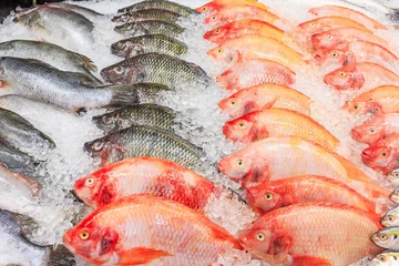 Fotobehang Vis Bevroren Nile Tilapia Fish in een stapel ijs in de supermarkt, gemengde vis te koop op een markt Achtergrond met verse vis met ijsheek