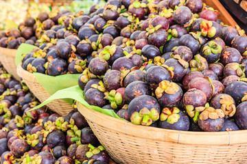 Fresh mangosteen queen of fruits (Garcinia mangostana Linn) in the basket at supermarket, healthy purple mangosteen fruit food