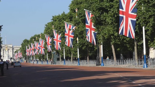 The flags of Britain are hanging along the road.